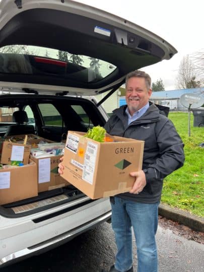 aaron goff holding a box of food for donation